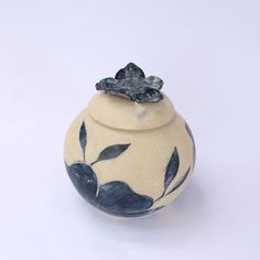 a blue and white vase with leaves on it