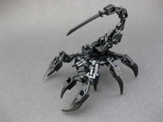 a black and silver robot with claws on it's back