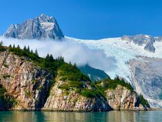 the mountains are covered in snow and clouds