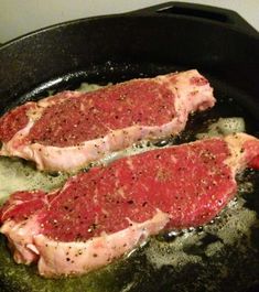 two raw meats cooking in a skillet on top of a stove burner