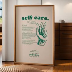 there is a framed poster on the floor with words about self care and hand gestures