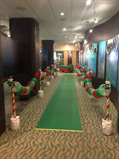 an indoor golf course decorated for christmas with candy canes and decorations on the ground