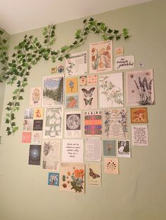 a wall covered with lots of different types of cards and plants growing on top of it