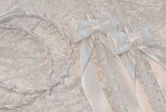 two pieces of white satin with bows and beads on them are laying next to each other