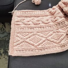 a pink knitted bag sitting on top of a couch