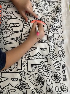 a person drawing on a sheet with markers