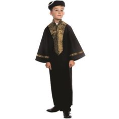 a young boy dressed in a black and gold priest outfit, standing with his hands on his hips