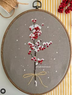 a cross stitch pattern with red and white flowers in the center on a gray background