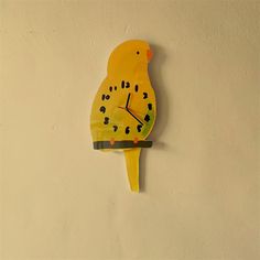 a yellow bird clock mounted to the side of a wall