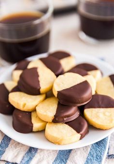 chocolate dipped cookies on a plate with coffee in the background