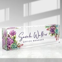 an office name sign with succulents and flowers painted on the front side