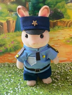 a stuffed animal is dressed in a police uniform and standing on the ground next to a painting