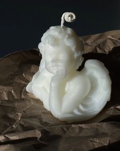 a white statue sitting on top of a piece of wax paper