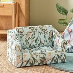 a living room scene with focus on the sofa and chair, which is decorated in tropical print