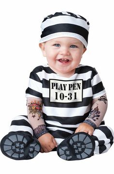 a baby in a jail outfit sitting on the ground