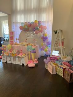 a room filled with lots of balloons and desserts on top of wooden flooring