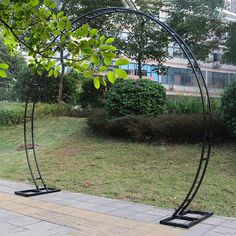 an outdoor sculpture is shown in the middle of a grassy area with trees and bushes