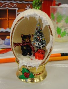 there is a small christmas ornament in the shape of a ball with two bears inside