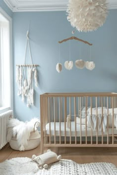 a baby's room with blue walls and white furniture