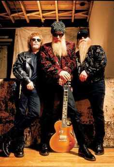 two men with long hair and beards are posing for a photo while holding an electric guitar