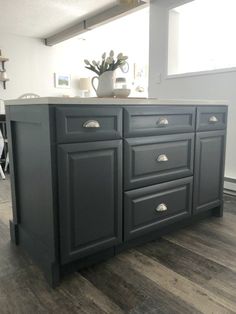 the kitchen island is painted in dark gray