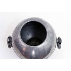 a metal bowl with two handles on the top and one in the middle, against a white background