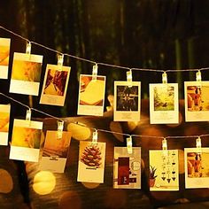 there are many pictures hanging on the clothes line with string lights in front of them