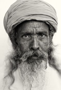 black and white photograph of an old man wearing a turban with long hair