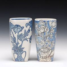 two blue and white vases sitting next to each other