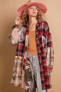 a woman wearing a red hat and plaid shirt is standing in front of a brown wall