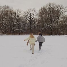 two people walking in the snow holding hands