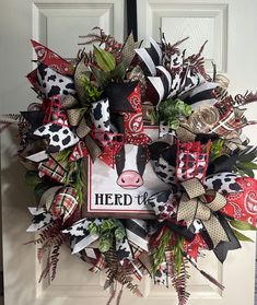 the wreath is decorated with farm animals and ribbon decorations on it's front door