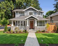 a nice house with landscaping and trees in the front yard, on a sunny day