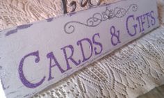 a wooden sign that says cards and gifts on the side of a bed with lace