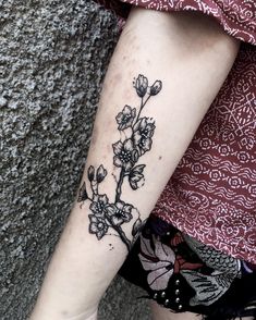 a woman's leg with a flower tattoo on her left arm and the bottom half of her leg