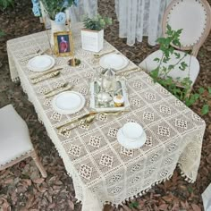 the table is set with white dishes and place settings for two people to sit at