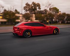 a red sports car driving down the road