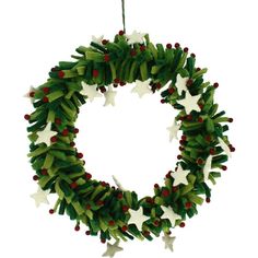 a green wreath with white stars and red berries hanging from the front on a string