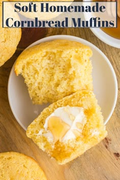 a muffin cut in half on a white plate with butter and honey next to it