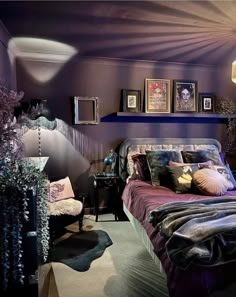 a bedroom with purple walls and pictures on the wall above the bed, along with other decor items