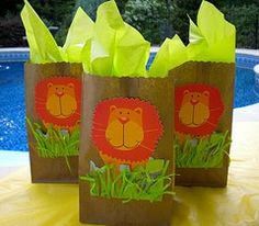 two brown paper bags with lion faces on them sitting next to a pool and trees