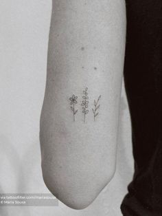 a woman's leg with three small flowers on it