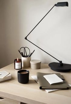 an office desk with a lamp, notebooks and other items on the top shelf