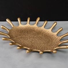 a gold plate with spikes on it sitting on a table