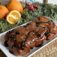 a white plate topped with oranges and blueberries covered in syrup next to other fruit