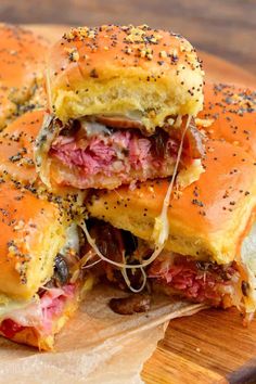 two sandwiches stacked on top of each other with meat and cheese in between the buns