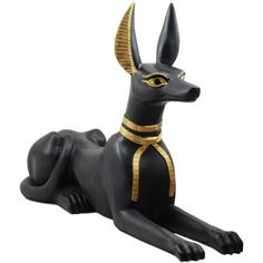 an egyptian cat statue with gold accents on it's head and tail, laying down