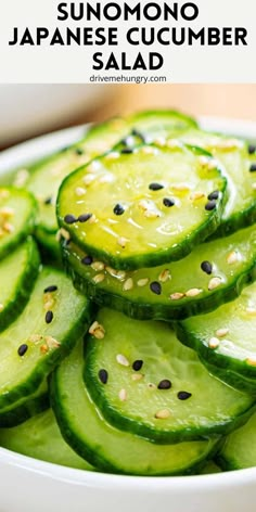 sliced cucumber in a white bowl with sesame seeds on top and text overlay