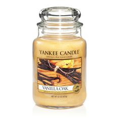 a yankee candle with vanilla and cinnamon sticks in the jar, on a white background