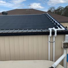 an image of a roof that has some pipes attached to it and is in front of a house